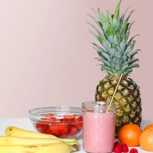 a pineapple, bananas, raspberries, and other fruit