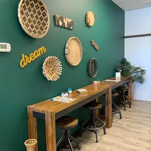 a green wall with a wooden table and chairs