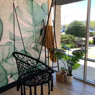 a hanging chair in front of a window