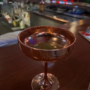 a glass of cocktail on a bar