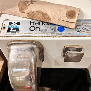 a dirty toilet with a roll of toilet paper on it