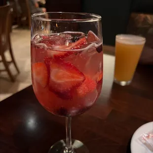 a close up of a glass of water with strawberries in it