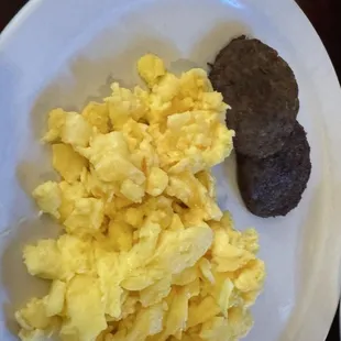 Scrambled eggs with some sausage patties.