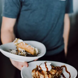 a man holding two plates of food