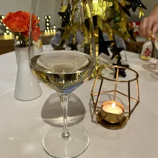 a glass of white wine on a table