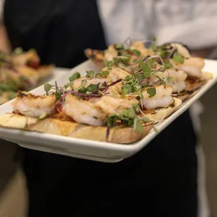 a person holding two plates of food