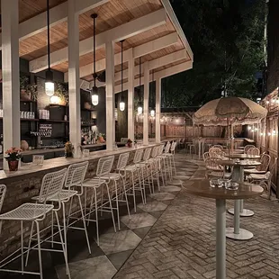 an outdoor bar with chairs and umbrellas