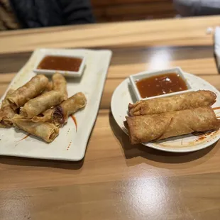 Veggie spring rolls on the left and pork egg rolls on the right with dipping sauce.