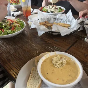 Corn &amp; Crab Chowder w/ various salads in bg.