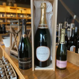 a bottle of champagne and two bottles of wine