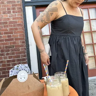 a woman standing in front of a table with drinks