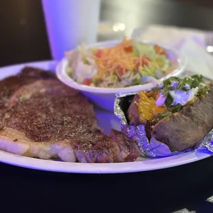 a plate of steak and a baked potato
