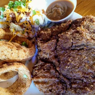 Fried pork chop, onion rings, and loaded mashed potatoes