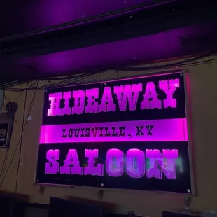 a neon sign above the bar