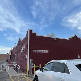 a white car parked in front of a red building