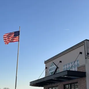 an american flag flying in front of a restaurant