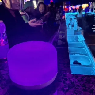 a purple light on a bar counter