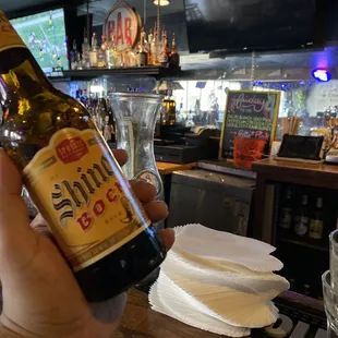 a person holding a bottle of beer