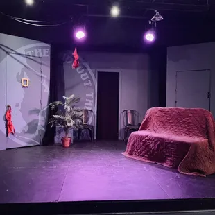 a stage with a couch and a chair