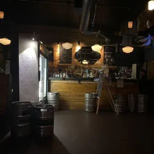 a bar with beer kegs in the foreground