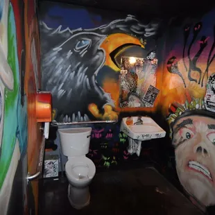 a bathroom with a mural on the wall