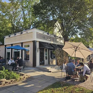 a group of people sitting outside of a restaurant