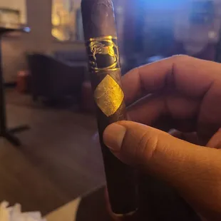 a hand holding a cigar