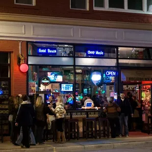 a group of people standing outside of a bar