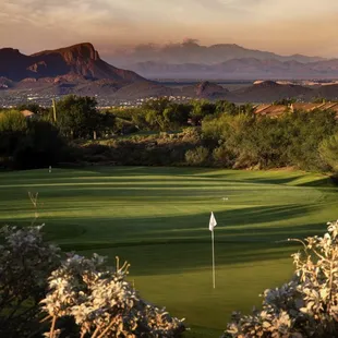 a golf course with mountains in the background