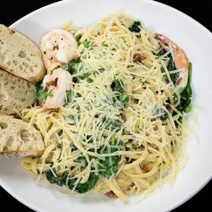 a plate of pasta with shrimp and spinach