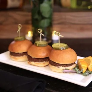three sliders with pickles on them