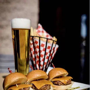 a plate of burgers and a glass of beer