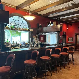 a bar with red chairs