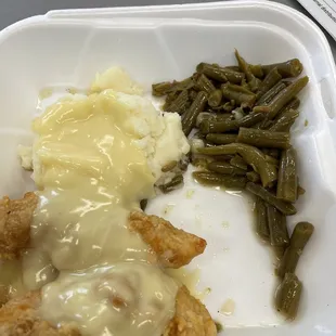 Country friend chicken with gravy, green beans, and mashed potatoes.