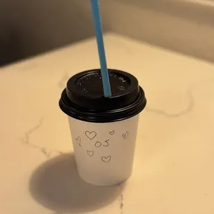 a cup of coffee with a blue straw