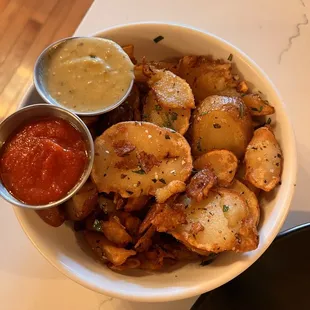 Side of country potatoes with house ketchup and house hot sauce