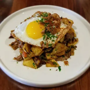 Duck Confit Hash - shredded duck confit, potatoes, seasonal veggies, egg sunny side up, duck skin