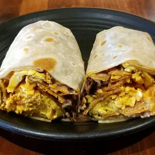 Migas Breakfast Burrito - scrambled eggs, torillas chips, roasted poblano peppers, salsa roja, crema, avocado, red onion, black beans