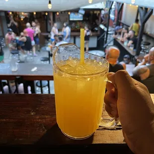 a person holding a glass of orange juice