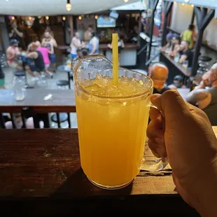 a person holding a glass of orange juice