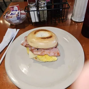 Breakfast sandwich on bagel with ham cheese and egg.