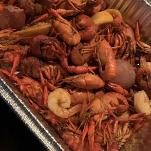 a tray of cooked shrimp and potatoes