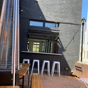 a view of a patio area with tables and stools
