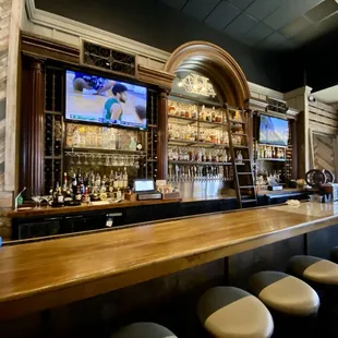 a bar with stools and a television