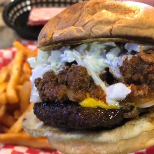 a hand holding a hamburger and fries
