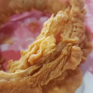 a fried onion ring in a basket