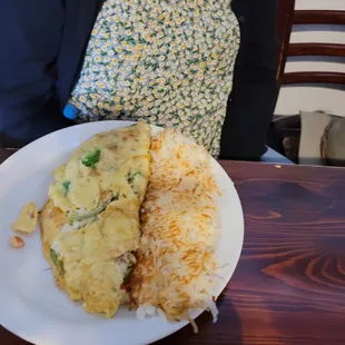 a woman sitting at a table with a plate of food