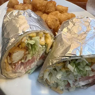 a sandwich and tater tots on a plate