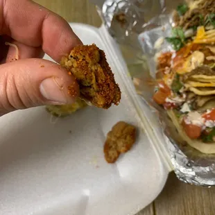 a hand holding a piece of food