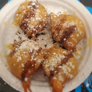 a plate of hotdogs covered in powdered sugar